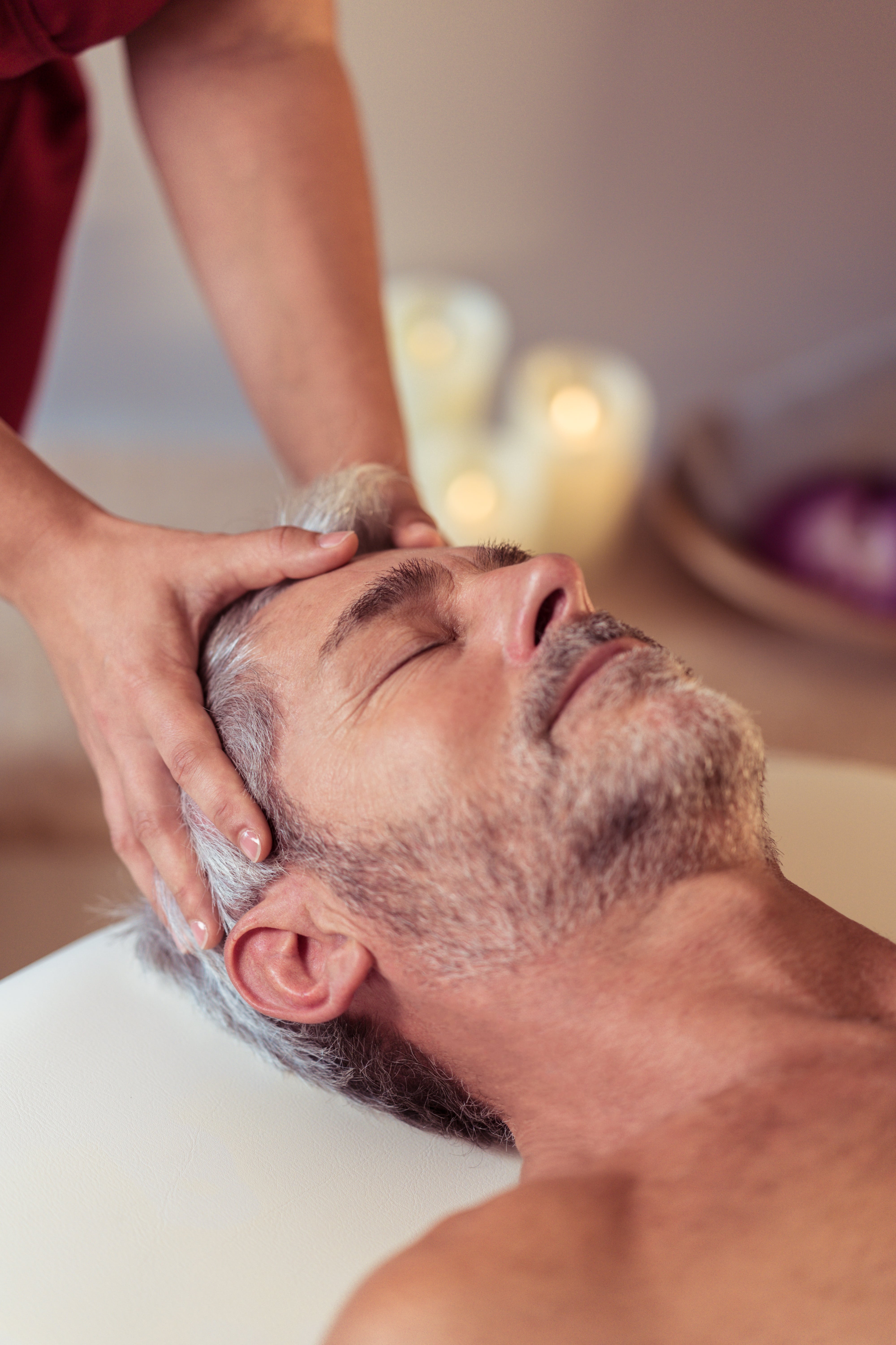 Mains posés sur le crâne d'un homme pour un massage visage et cuir chevelu - Alliance Pornic